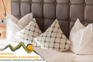 a bed with pillows on it with the inclusive furniture and handcrafted magazine at Oberstdorfer Ferienwelt in Oberstdorf +47 photos