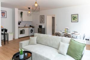 a living room with a white couch and a kitchen at Modernes Apartment im Essener Stadtkern mit Parkplatz in Essen