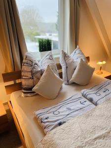 a bed with pillows on it with a window at Gästehaus Rosenkamp in Scharbeutz