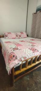 a bedroom with a bed with a pink quilt on it at GARDEN House in Ban Phru Ching (1)