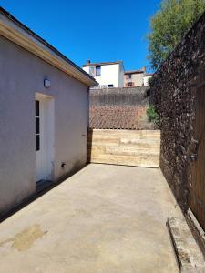 an empty parking lot next to a brick wall at Logement 2 cité de caractère in Mallièvre +5 photos