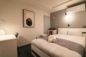 a bedroom with a bed with two towels on it at TAKETO STAY PREMIERE SAPPORO EKi in Sapporo