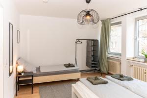 a bedroom with two beds and a chandelier at Modernes Apartment im Essener Stadtkern mit Parkplatz in Essen