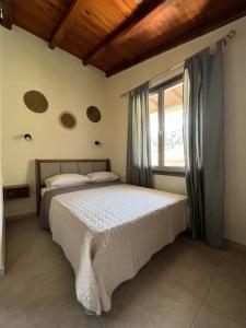 a bedroom with a bed and a window at Ninemo Residences Skiathos in Achladies