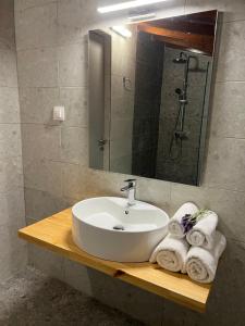 a bathroom sink with towels on a wooden counter at Ninemo Residences Skiathos in Achladies +16 photos