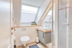 ein Badezimmer mit Toilette, Waschbecken und Fenster in der Unterkunft Schmidt-einander W 8 in Norderney