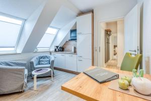 ein Wohnzimmer mit einem Tisch und einer Küche in der Unterkunft Schmidt-einander W 8 in Norderney