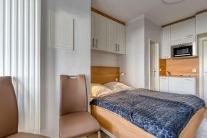 a bedroom with a bed and a chair at Alte Teestube W 70 in Norderney