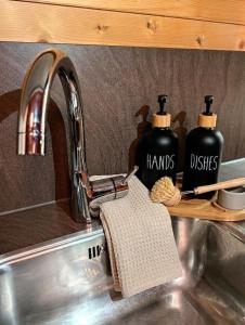 a kitchen sink with two bottles ofhards dishes on a shelf at Chalet Rattendorf 139 in Rattendorf +18 photos
