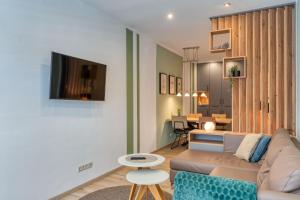 a living room with a couch and a tv on a wall at Alte Teestube Schmidt 59 Links in Norderney