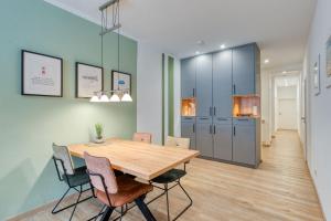 a dining room with a wooden table and chairs at Alte Teestube Schmidt 59 Links in Norderney +8 photos