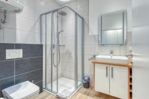 a bathroom with a shower and a toilet and a sink at Alte Teestube Schmidt 59 Links in Norderney