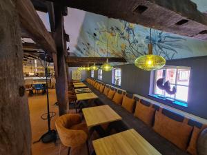 a restaurant with wooden tables and chairs and a mural at Ahrenshof 7 in Bad Zwischenahn