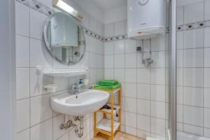 a bathroom with a sink and a mirror at Alte Teestube Schmidt 58 in Norderney +8 photos