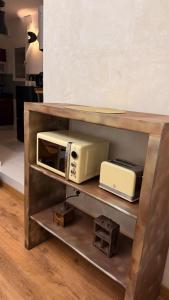 a microwave and a toaster oven on a shelf at Apartamentos ÁBREME Y VERÁS in Arcos de la Frontera