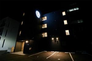a building with a clock on the side of it at night at TAKETO STAY PREMIERE SAPPORO EKi in Sapporo