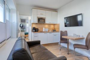 a living room with a couch and a kitchen at Alte Teestube 69 2 Raum in Norderney