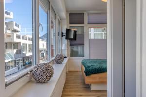 a room with a balcony with a bed and a tv at Alte Teestube 69 2 Raum in Norderney