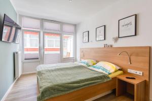 a bedroom with a bed and a table and windows at Alte Teestube Schmidt 68 in Norderney