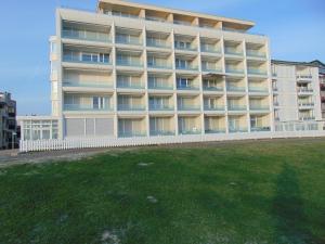 a large building with a lawn in front of it at Alte Teestube Schmidt 68 in Norderney