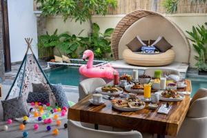 a table filled with food next to a pool at Lalasa Villas Canggu in Canggu