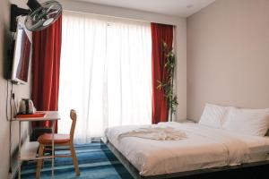 a bedroom with a bed and a desk and a window at Love Inn Hotel Kuchai Lama in Kuala Lumpur
