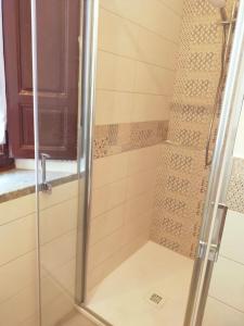 a shower with a glass door in a bathroom at La Finestra sul Corso 3 in Arcidosso