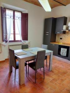 a dining room table and chairs in a kitchen at La Finestra sul Corso 3 in Arcidosso