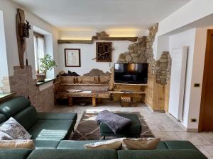 a living room with a couch and a tv at Appartamento Il Conte di Avoscano in Piaia