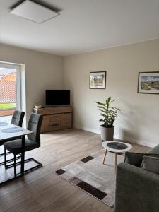 a living room with a couch and a table and a tv at Ferienwohnung Arendsee in Arendsee