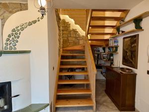a wooden staircase in a room with a stone wall at Appartamento Il Conte di Avoscano in Piaia