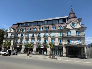 a large building with a clock on the top of it at VIS Palm Hotel Ganja in Ganja