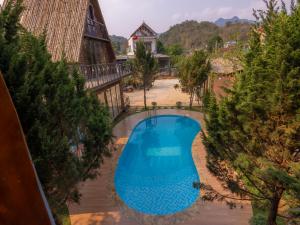 an overhead view of a blue swimming pool with trees at Homestay Gió Mộc !!! in Làng Môn