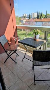a table and chairs on a balcony with a potted plant at chez MARINO antony real in Orange +4 photos