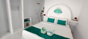 a white bedroom with a white bed with green pillows at Casa di Stella in Ngurblut