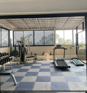 a gym with treadmills and machines in a room at Amarin Samui Hotel - SHA Plus Certified in Mae Nam