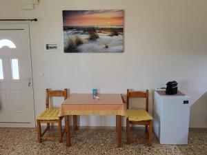 a dining room table with two chairs and a refrigerator at Filippos Apartments "Room 5" in Spartià +8 photos