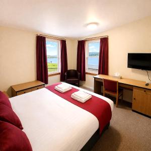 a hotel room with a bed and a desk with a computer at The Brae Hotel in Brae