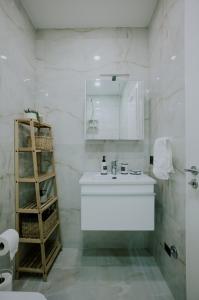 a white bathroom with a sink and a shelf at Elrea Living 2 Central 1BR with Dajti & Skyline View in Tirana +52 photos