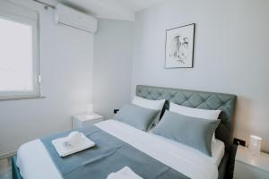 a bedroom with a large bed with blue pillows at Elrea Living 2 Central 1BR with Dajti & Skyline View in Tirana