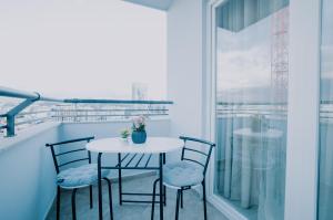 a balcony with a table and chairs and a window at Elrea Living 2 Central 1BR with Dajti & Skyline View in Tirana