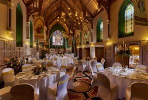a room with white tables and chairs in a church at Temple Gate Hotel in Ennis