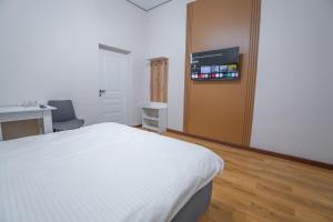a bedroom with a bed and a desk and a tv at Nura Hotel in Shymkent +5 photos