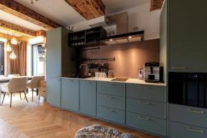 a large kitchen with blue cabinets and a table at Allure Chalet, z prywatnym jacuzzi, z widokiem na góry in Dzianisz