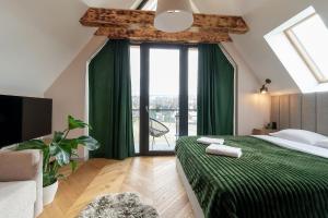 a bedroom with a green bed and a large window at Allure Chalet, z prywatnym jacuzzi, z widokiem na góry in Dzianisz