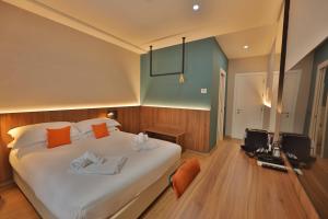 ein Schlafzimmer mit einem großen weißen Bett und einem Fernseher in der Unterkunft Moody smart & comfy Hotel in Terranuova Bracciolini