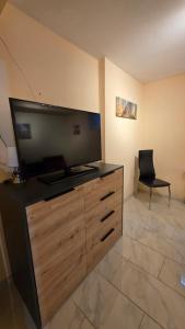 a living room with a large television and a chair at B&M Apartment in Zierenberg