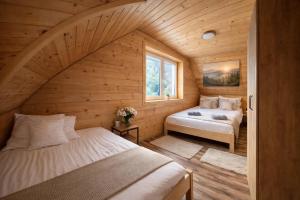 a bedroom with two beds in a wooden cabin at UROCZYSKO-POLAŃCZYK Prywatne Jacuzzi i Sauna w cenie !!! in Polańczyk