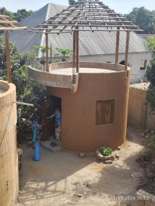 two people standing outside of a building with an umbrella at One Love - One Heart Lodge in Tanji
