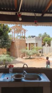 a kitchen sink with a view of a building at One Love - One Heart Lodge in Tanji